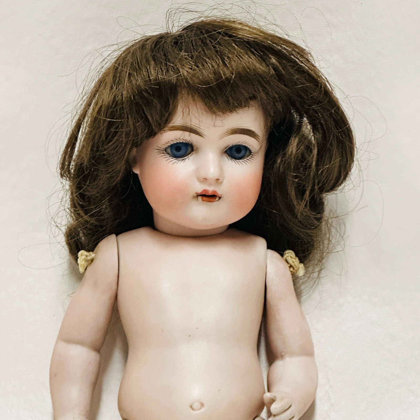 Antique All Bisque Doll 4: Likely Kestner, open mouth with teeth, firing lines around mouth, dark blue sleep eyes, open mouth with teeth, peg strung slant hip body, painted socks and shoes, one finger chip, head has hairlines a
