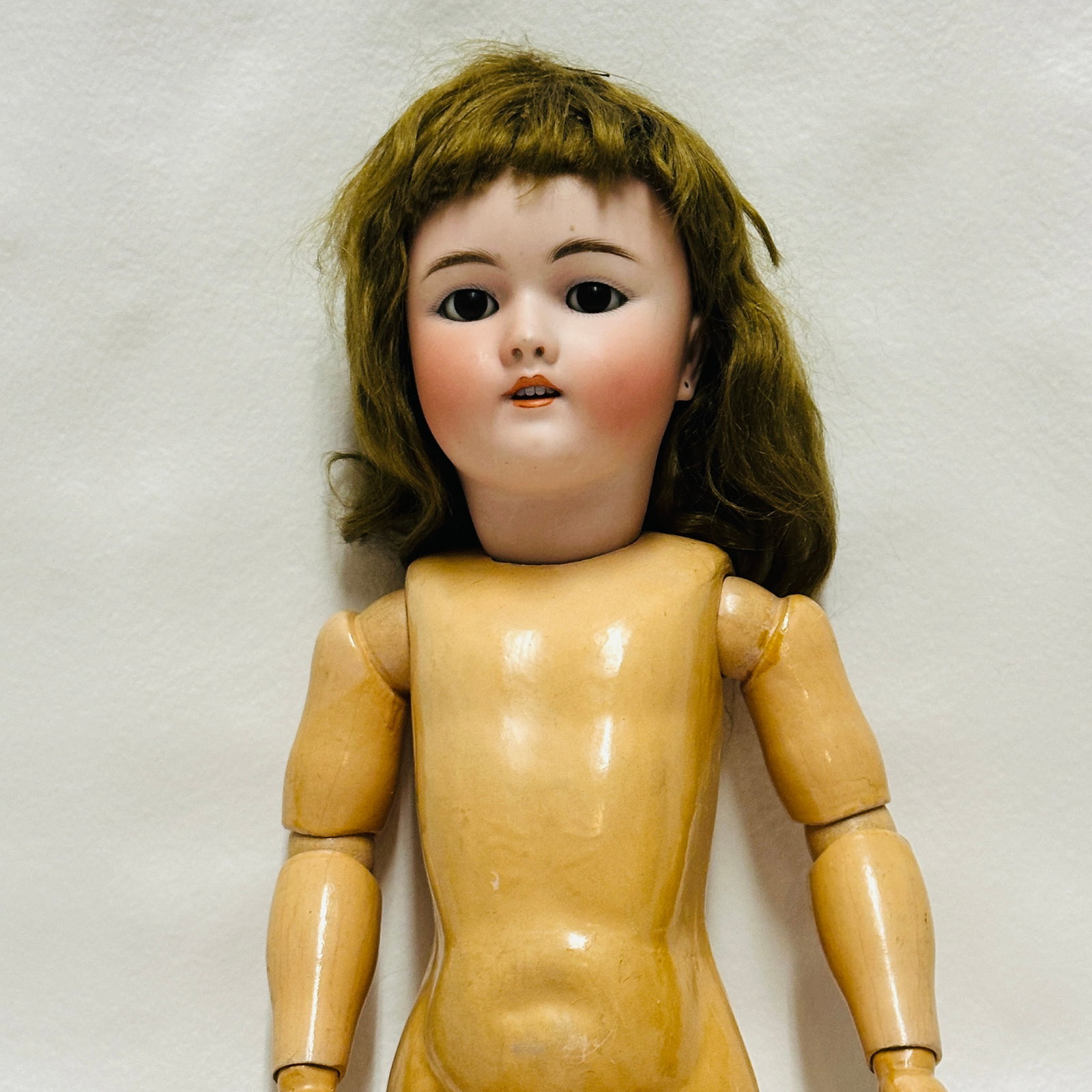 Heinrich Handwerck Simon Halbig Antique Bisque Socket head Doll: Lively bisque, peach coloring, dark brown sleep eyes and open mouth with four teeth, original mohair wig, earring holes with no chips, on marked Handwerck body with some minor loss of finish, indiscer