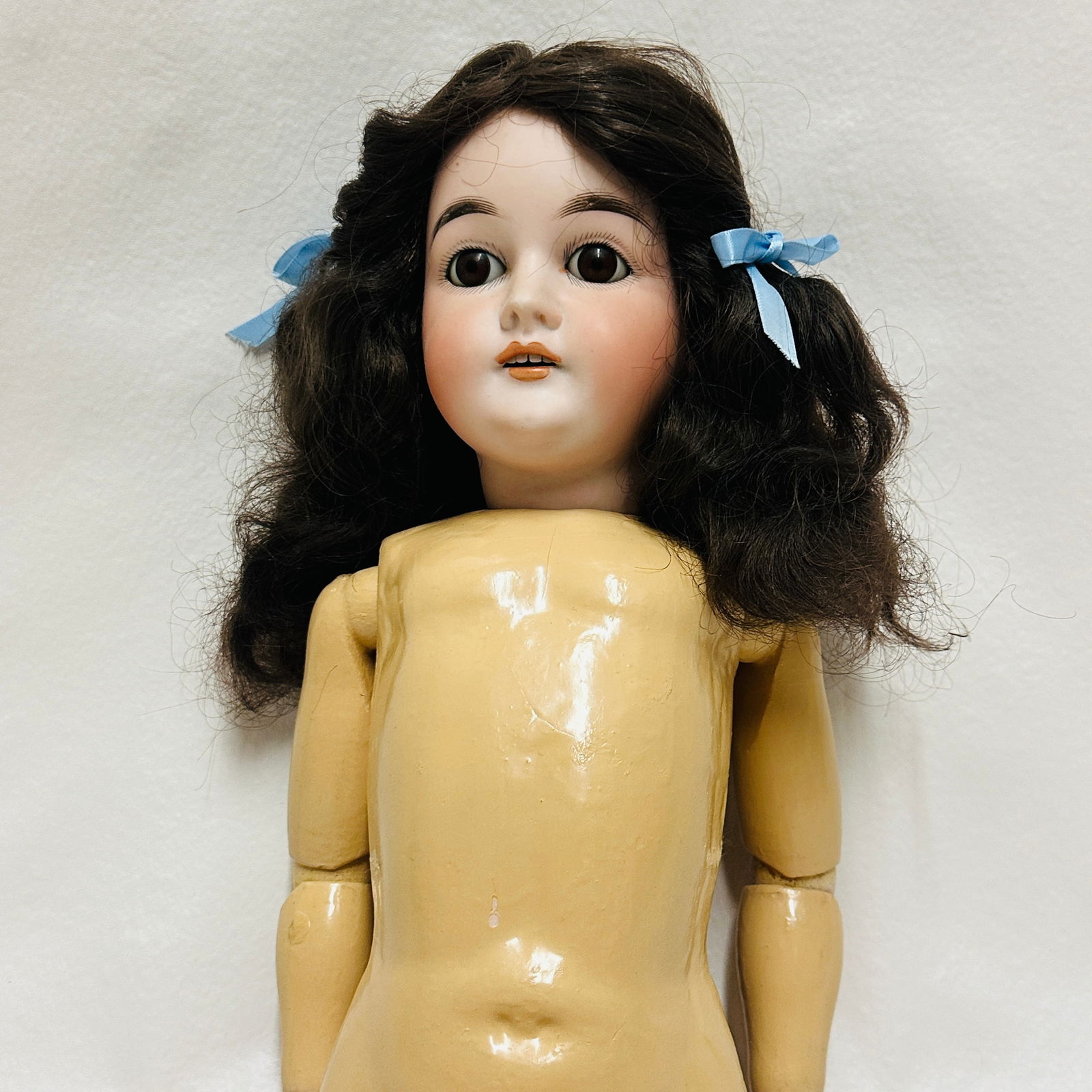 Antique Handwerck Doll: Handwerck, Pretty face with nice painting, large brown paperweight eyes, open mouth with four teeth, dark brown full wig, on wood and composition body with no repaint in good condition ---------------