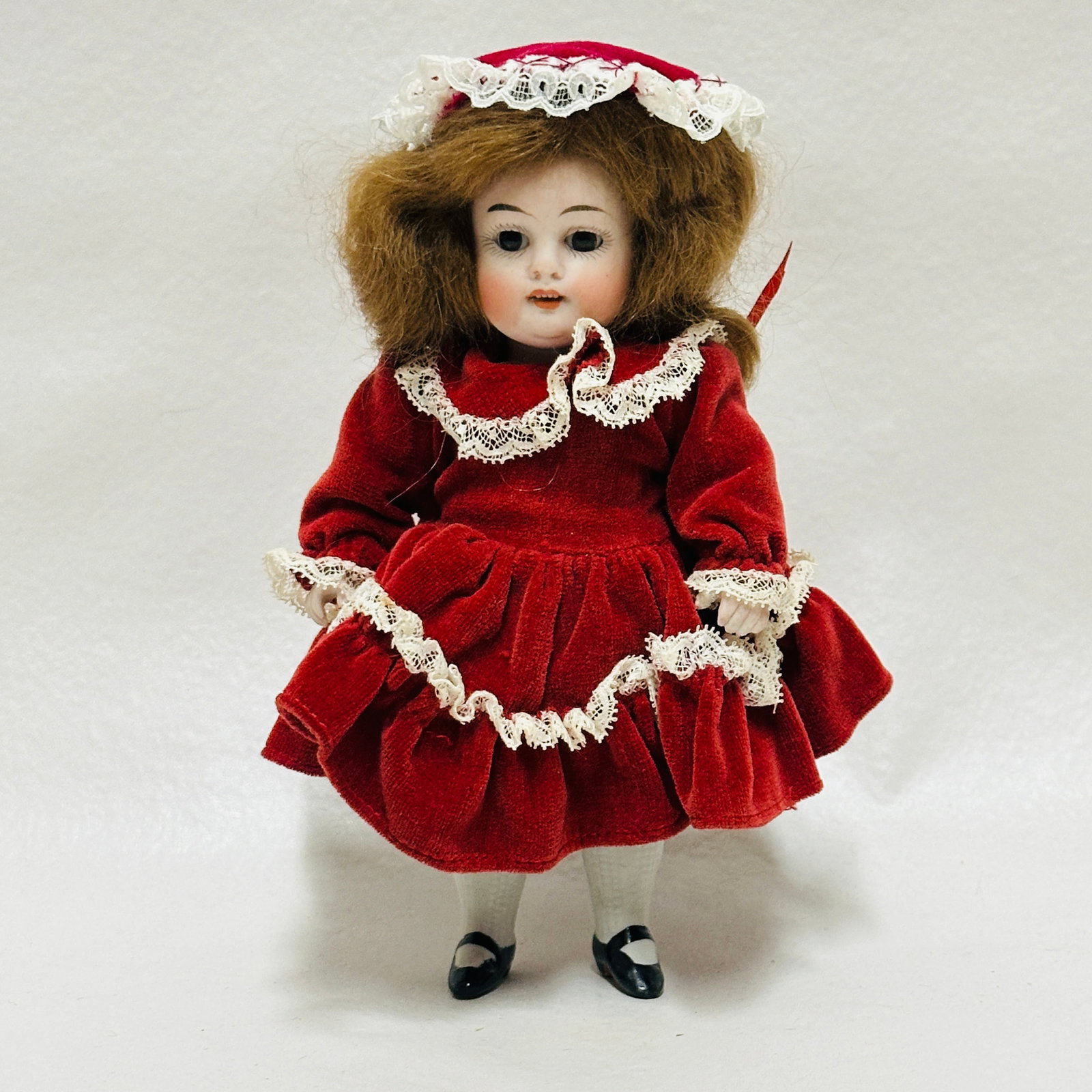 Antique All Bisque Doll 208 stamped Germany: Brown sleep eyes, single stroke eyebrows, open mouth with four teeth, double chin, all bisque body with repair to left thumb, painted socks and shoes with blue stripe, replacement costume and hat. Wig