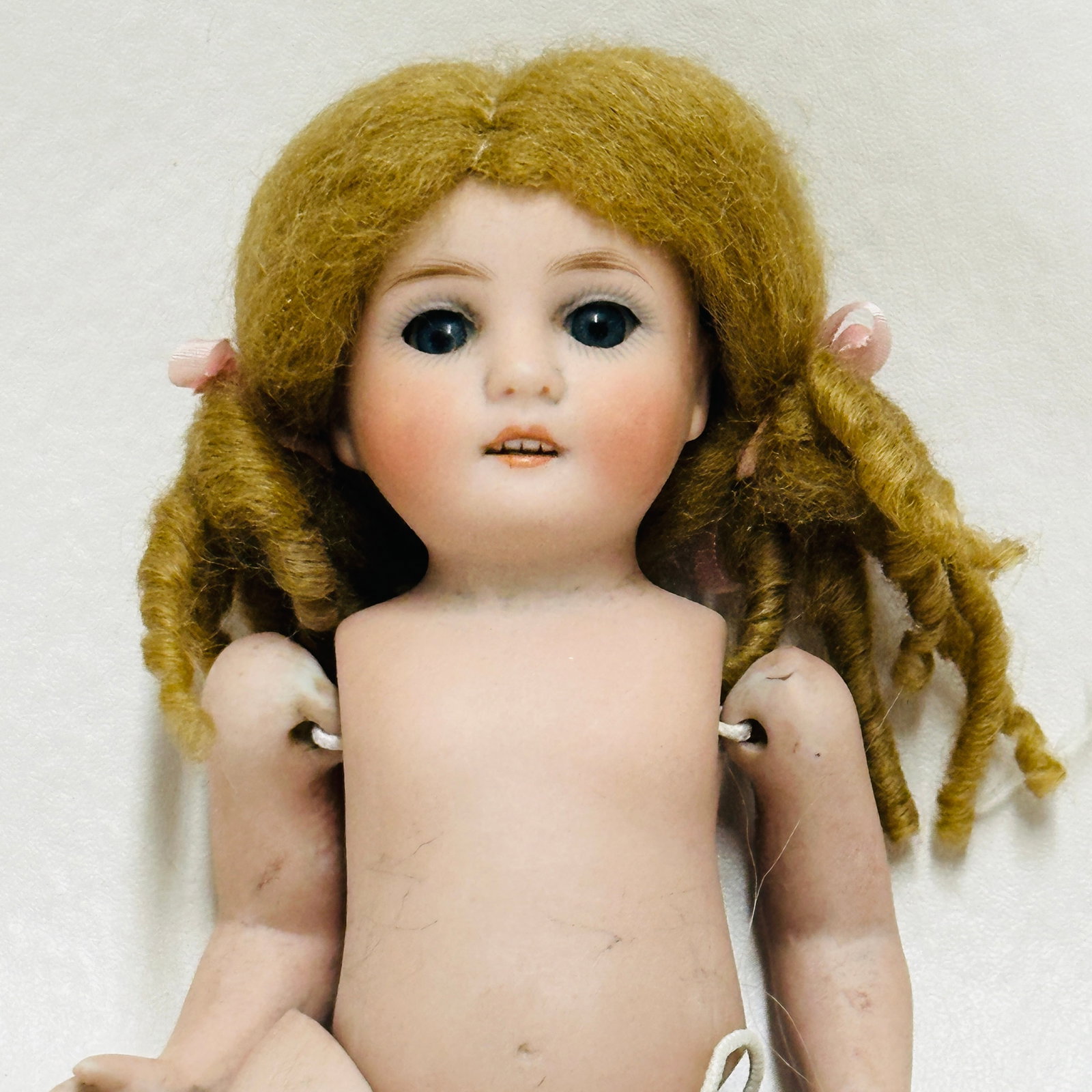 Kestner 150 All Bisque Doll: Kestner 150, Blue painted sleep eyes, open mouth with four teeth, replaced mohair wig, painted socks and shoes with blue stripes, head reattached, All Bisque Doll chips to upper leg. Back of head and 