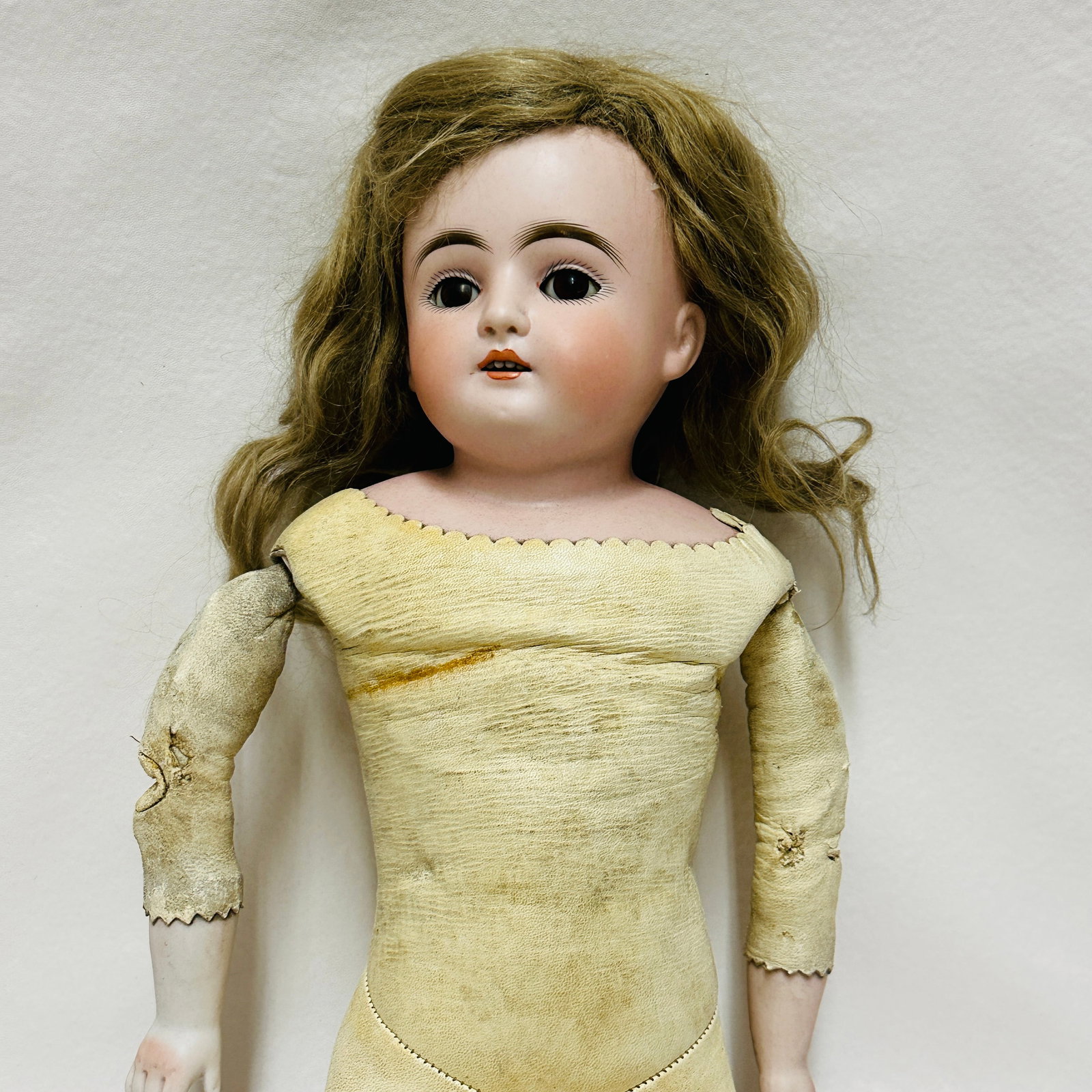 Likely Kestner Bisque Shoulderhead Doll with leather body: Likely Kestner, Turned head fixed neck dark brown sleep eyes, open mouth with four teeth and chin dimple, original pate and mohair wig,on kid body with bisque lower arms, individually stitched toes, g
