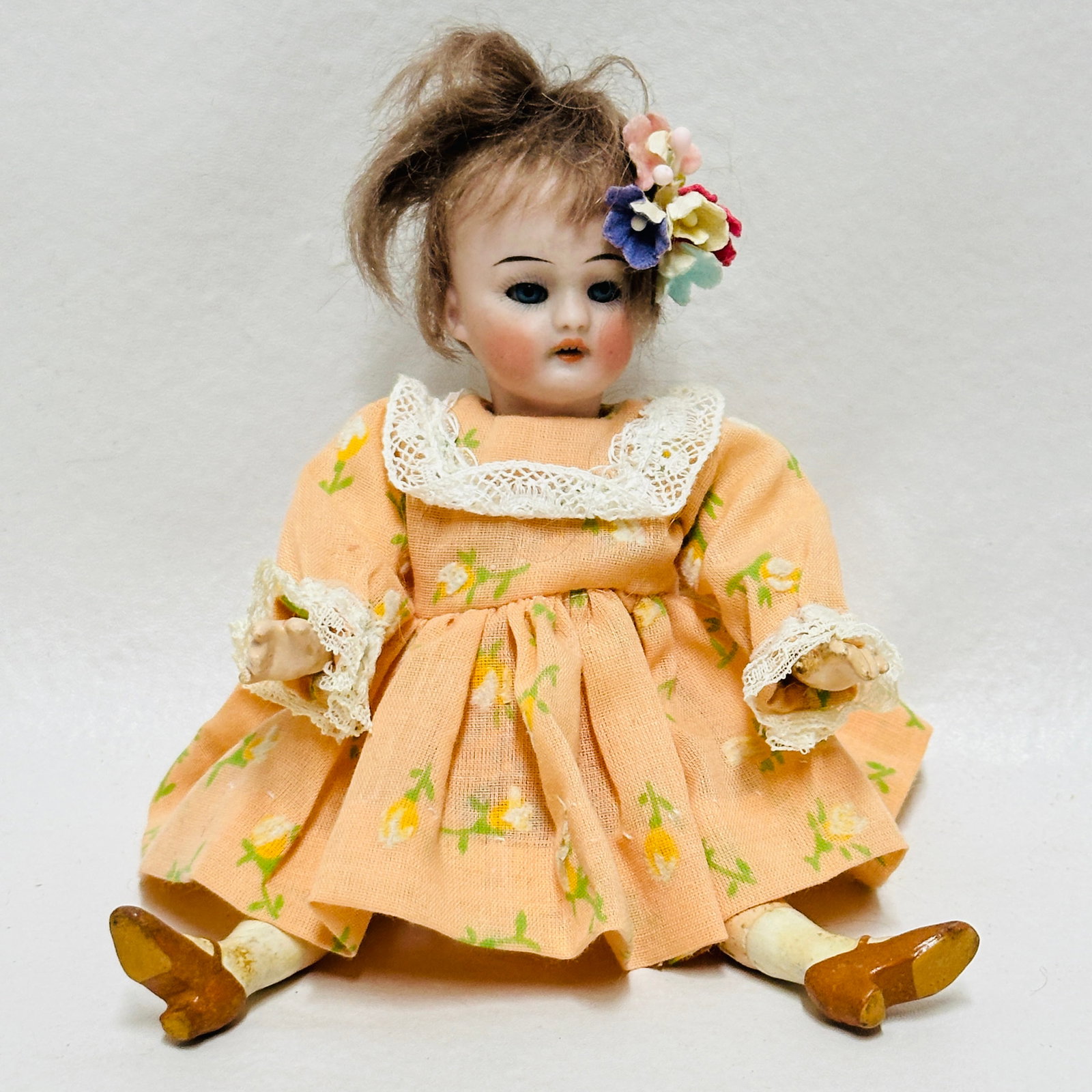 Antique Bisque Head Doll in Floral Outfit: Dark blue sleep eyes, open mouth with teeth, original mohair wig, compo flapper body with painted shoes and socks, vintage dress and hair decoration, Antique Bisque Head Doll in Floral Outfit --------