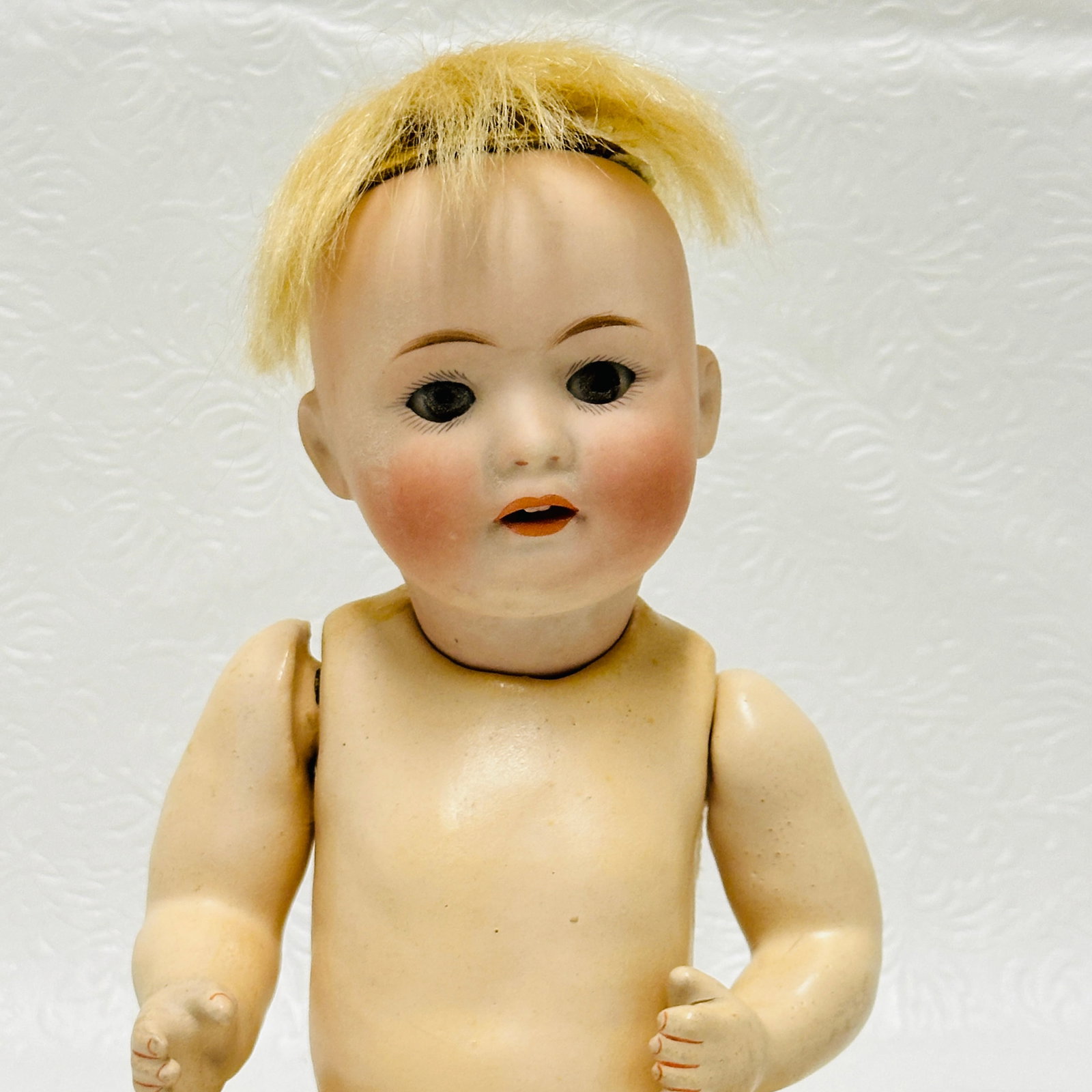 Bisque socket head Nippon Antique Baby Doll: Bisque socket head Nippon Antique Baby Doll, Original cardboard pate with remains of original mohair wig, dark blue sleep eyes, open mouth with two square teeth, compo baby body with original finish,