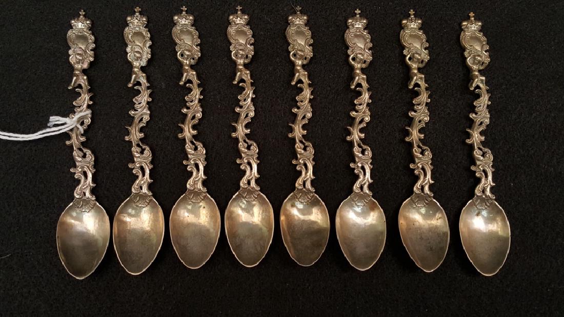 Scrolling Handle SILVER Spoons, Set of 8: Silver spoon designed with a fancy scroll pattern handle with a small boy holding a crowned shield / cross. There is a "Crowned R" mark on the back of each spoon. 121.8 DWT