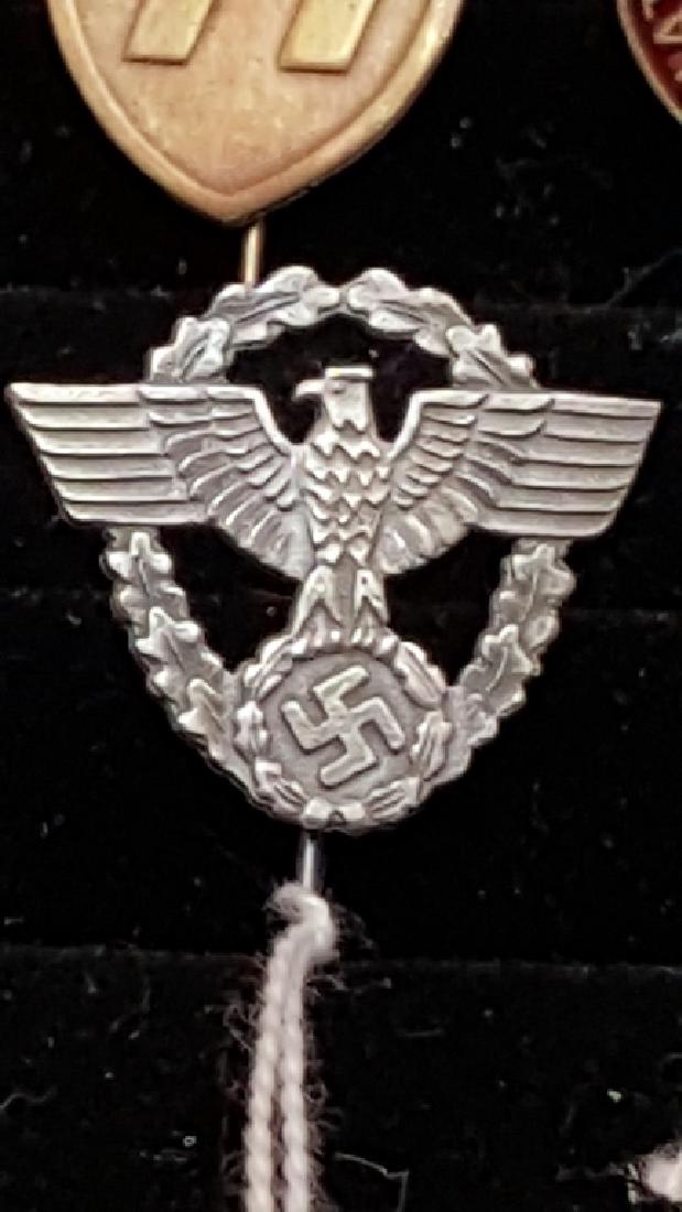 Silver Police Cap Eagle German WWII Stick Pin: This Silver Police Cap Eagle features an open wreath of oak leaves and a superimposed open-winged eagle. The eagle grasps a wreath and raised mobile swastika. Part of a 44 Piece GERMAN WWII COMBAT AND