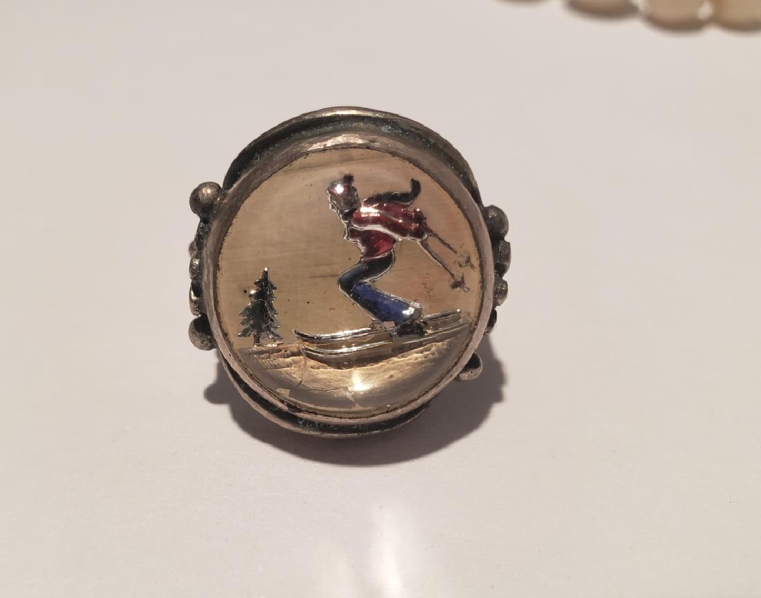 Essex Crystal or Intaglio Skier Ring: Appx. .75" Essex crystal depicting a cross country skier. Ring setting marked "Sterling"