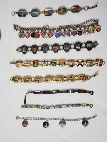 Group of 8 Charm Bracelets / Travel Bracelets: 1) French, 7.25", 2) Washington D.C, sterling, 4 charms, 3) 3 color maple leaves, gold tone, 4) shield shaped charms, Canadian provinces, 5) Necklace, German cities, dense with charms, 6) Niagara Fall