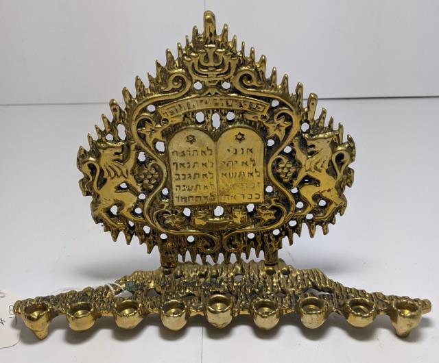 **Small Brass Menorah With 10 Commandments: Brass menorah 8.5" wide x 5.5" tall. With lions flanking the 10 commandments. Signed illegibly on reverse.