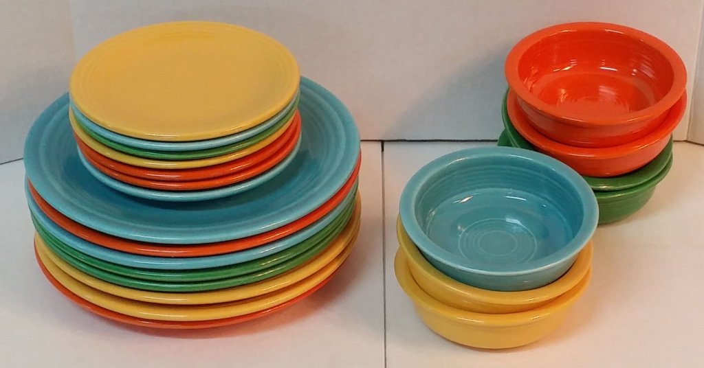 25 Piece Vintage Fiesta Plates and Bowls: 8 large plates and 7 small. Along with 7 dessert or cereal bowls. The colors are yellow, green, blue and orange.