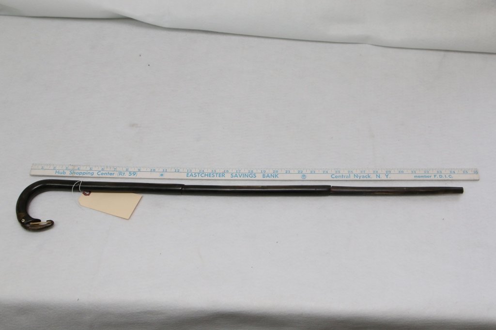An amusing walking stick in Elephant form: The shaft made of horn (?); the Elephant head at the handle of cane. 34.5" overall.