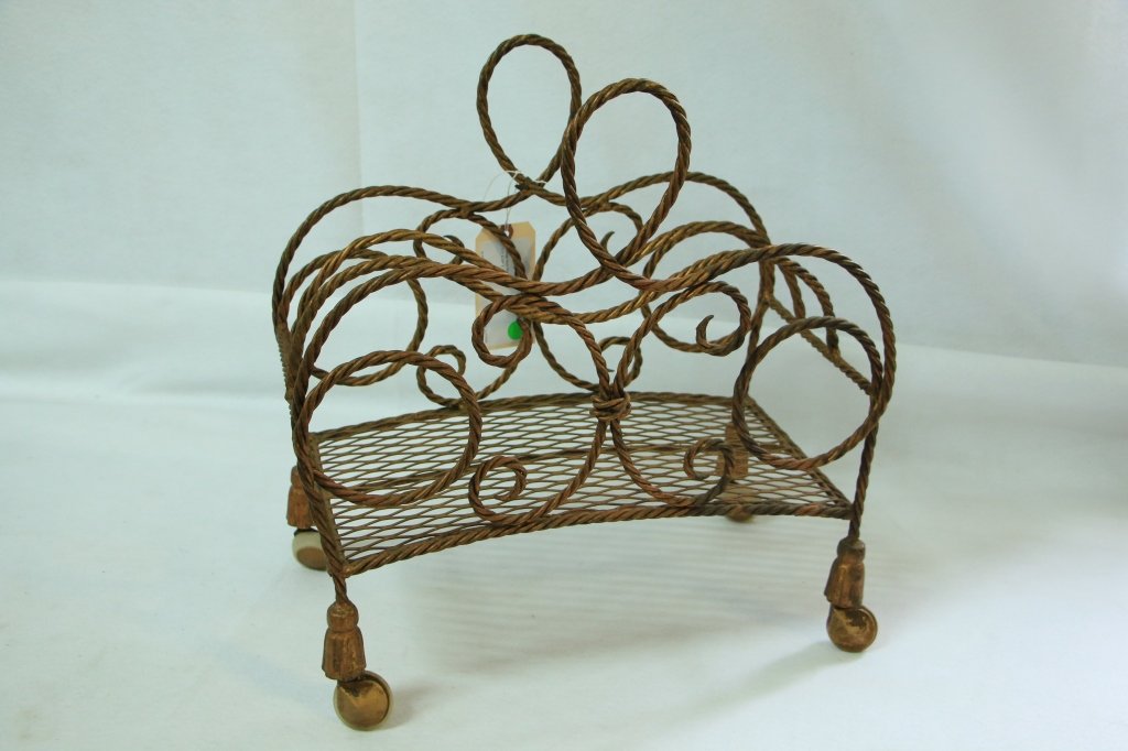 A rope and tassel magazine stand.: 1960's fine quality iron magazine rack in gold gilt finish. 20" high x 18.75" w x 10" deep.