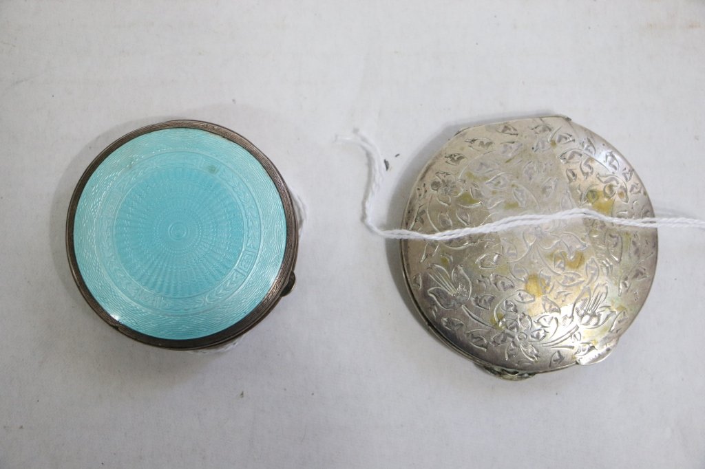 An .800 silver compact and an F&B sterling: and Enamel compact. The .800 compact with engraved flowers, the sterling compact with light blue enamel in good condition. Larger appx, 2.5" d.