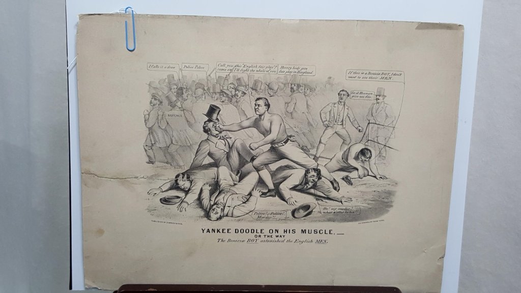 Antique Boxing Print "Yankee Doodle on his Muscle": An antique Currier & Ives print "Yankee Doodle on his Miuscle/ or the way/ The Benicia BOY Astonished the English MEN". Black & white unframed print side of print, print rebacked on cardboard for repa