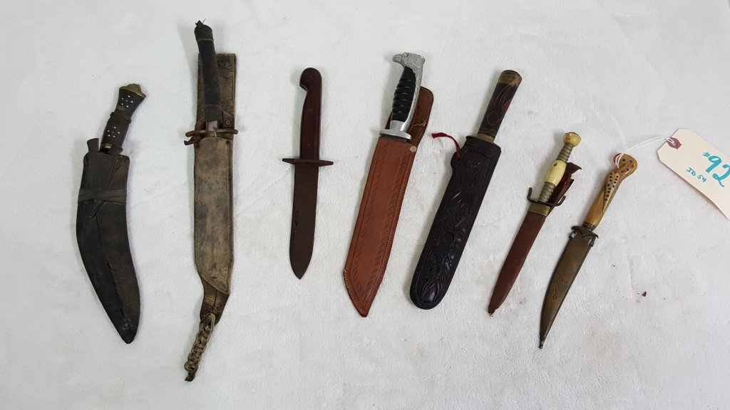 Group of 7 Antique, Decorative, & Primitive Knives: The age and make of some are unknown. The handles vary from wooden, bone?, and leather. There are also figural bird handles and a bronze sheath. Each knife has wear from age, as found.