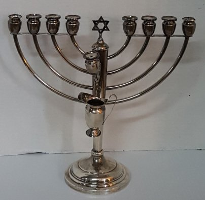 A Sterling Silver Menorah With Oil pitcher: The sterling silver menorah weighing appx. 10.3 oz troy and marked on the base. Just shy of 11" overall. 11.25" wide across arms. With shamash and oil pitcher. Decorated with Star of David at top cent