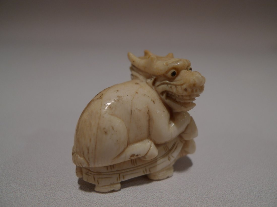 JAPANESE CARVED IVORY DRAGON NETSUKE MEIJI PERIOD: JAPANESE CARVED IVORY NETSUKE MEIJI PERIOD. DRAGON RIDING A TURTLE 1.75"