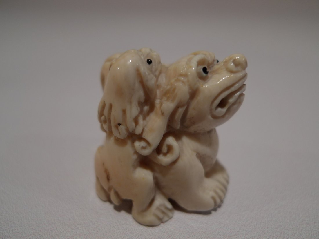 JAPANESE CARVED IVORY FOO LION NETSUKE MEIJI PERIOD: JAPANESE CARVED IVORY NETSUKE MEIJI PERIOD. DADDY FOO DOG WITH BABY FOO DOG. 1.5"