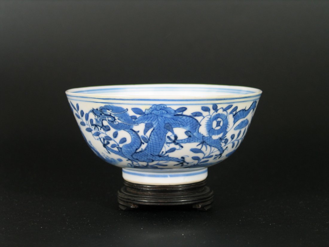 Chinese Blue and White Porcelain Dragon Bowl, Qianlong: Chinese Blue and White Porcelain Dragon Bowl, Qianlong mark and of the period. Dragon, foliate and rockery decoration. Diameter: 4 3/4 inches. Ht: 2 inches. Please note the wood stand is not included 