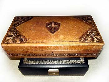 A leather jewellery box, having fitted interior with tr: A leather jewellery box, having fitted interior with tray, embossed with scrolling and having gilt tooling with central shield decoration; and another later leatherette jewellery box with silvered too