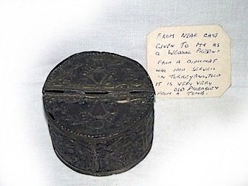 A silver metal ancient tin, embossed in relief with flo: A silver metal ancient tin, embossed in relief with floral scrolled moorish style panels, the lid hinging in two halves, with provenance note from a previous owner. (4in x 2.5in)