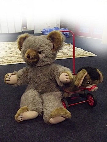 A Deans push-along donkey toy, with metal frame and rub: A Deans push-along donkey toy, with metal frame and rubber tyres, complete with harness; and a large Deans rag book childs playbear with pink pads and brown glass eyes, having brown ears and stitched