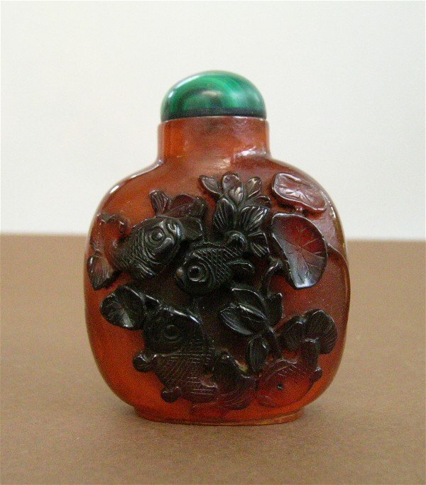 Snuff Bottle with Fish Design: Chinese Snuff Bottle, Brown cut to Amber with malachite type stopper. Lovely Koi and catfish carved relief. Spoon attached to lid. 2.75" X 2" X 1.25", weighs less than 3 oz.