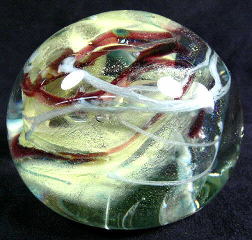 Ries Art Glass Paperweight 1977: CHRISTOPHER RIES: Clear paperweight with trapped air bubbles, yellow and reddish with white swirl. Signed Christopher Ries, 1977. Measures 3" H x 4" diameter. Weighs 2.5 lbs. Christopher Ries (America
