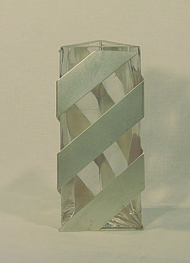 Clear glass vase Lino Sabattini - Marcello Morandini,: Clear glass and brushed metal triangular section vase . 1988. By Lino Sabbatini. Vaso a sezione triangolare in vetro cristallo e metallo spazzolato. Dimensions: cm 27,5 x 13