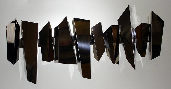 Bright Sculpture: Bright Sculpture, polished steel inox structure, 10 pieces geometrically irregular, Foldered in level, posterior plank for wall fixing. Posteriors lights. Dimensions: dim. cm. h 190 (74,8"x 100(39")x 