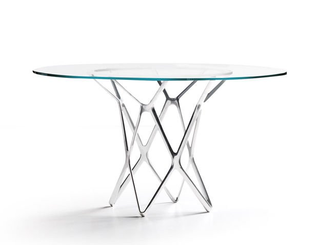 PATRICK NORGUET, ESTEL, table: Table Tori. A circular glass top table with a criss-cross aluminum base. Dimensions: h. 29 IN. - DIAM. 50 IN Tavolo Tori, Struttura in alluminio e piano in vetro. Dimensioni: H. 74 CM - DIAM. 127 CM