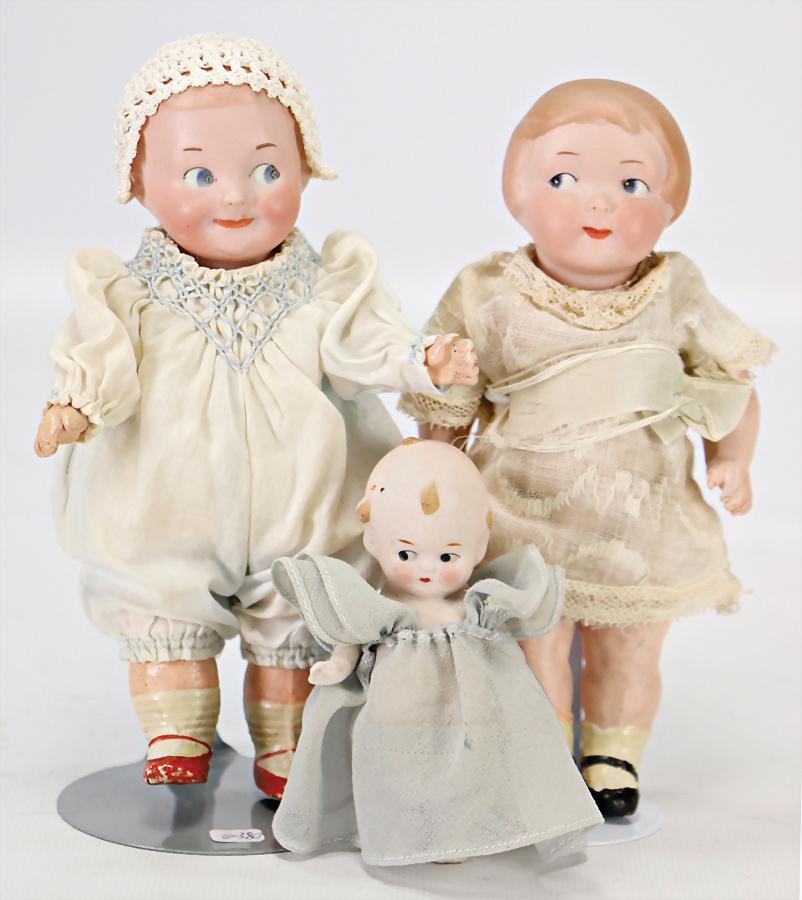 3 Porzellan-Puppen, 1 Ganzbiskuit-Kewpie, gem. I, 9,5: 3 Porzellan-Puppen, 1 Ganzbiskuit-Kewpie, gem. I, 9,5 cm, 2x AM, Googly, 1x gem. 210, 1x gem. 324, beide Vollkopf mit gemalten Schielaugen, Masse-Körper, bewegl. Arme u. Beine, anmodell. Schuhe u. St