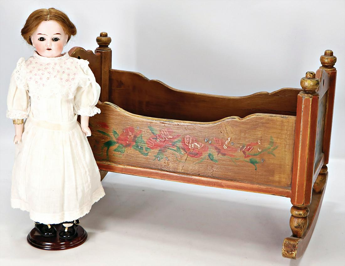 KUNO OTTO DRESSEL Puppenwiege, Holz, bäuerlich bemalt,: KUNO OTTO DRESSEL Puppenwiege, Holz, bäuerlich bemalt, L: 55 cm, H: 37 cm, 1x Biskuit-Porzellan-Brustblattkopf-Puppe, gem. geflügelter Kreis Germany, braune Schlafaugen, off. Mund, oben Zähne, Echt