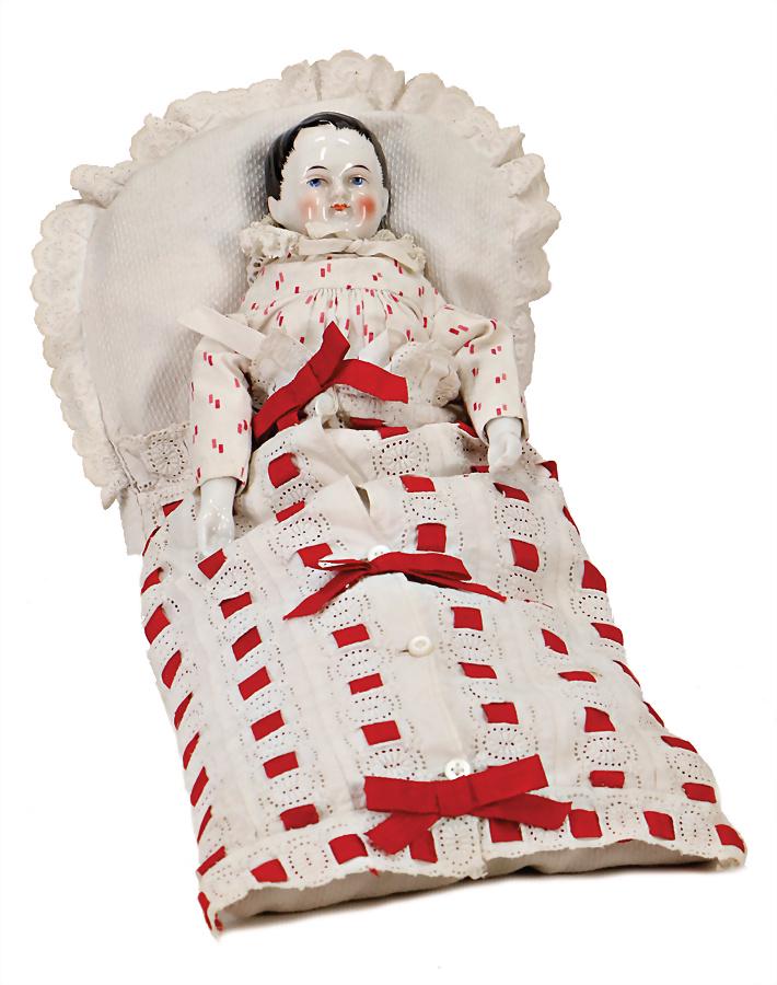 Christchild, enameled shoulder headed doll, modelled: Christchild, enameled shoulder headed doll, modelled hair, painted eyes, closed mouth, fabric body, enameled porcelain arm, in a swaddle wrap, big cushion 40 cm German Description Fatschenkind, glasie
