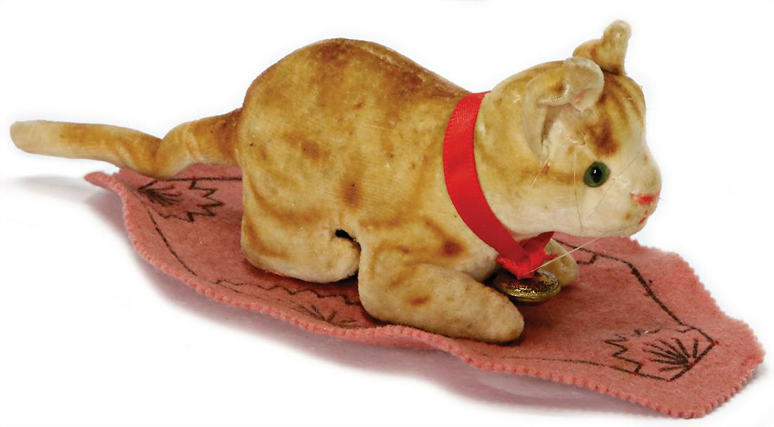 STEIFF cat, on a felt underlay, velvet, light brown: STEIFF cat, on a felt underlay, velvet, light brown striped, 1928-30, height: 5 cm, lenght: 14 cm, with button, block letters, long stretched F, green glass eyes, silk collar, probably more recent, ve