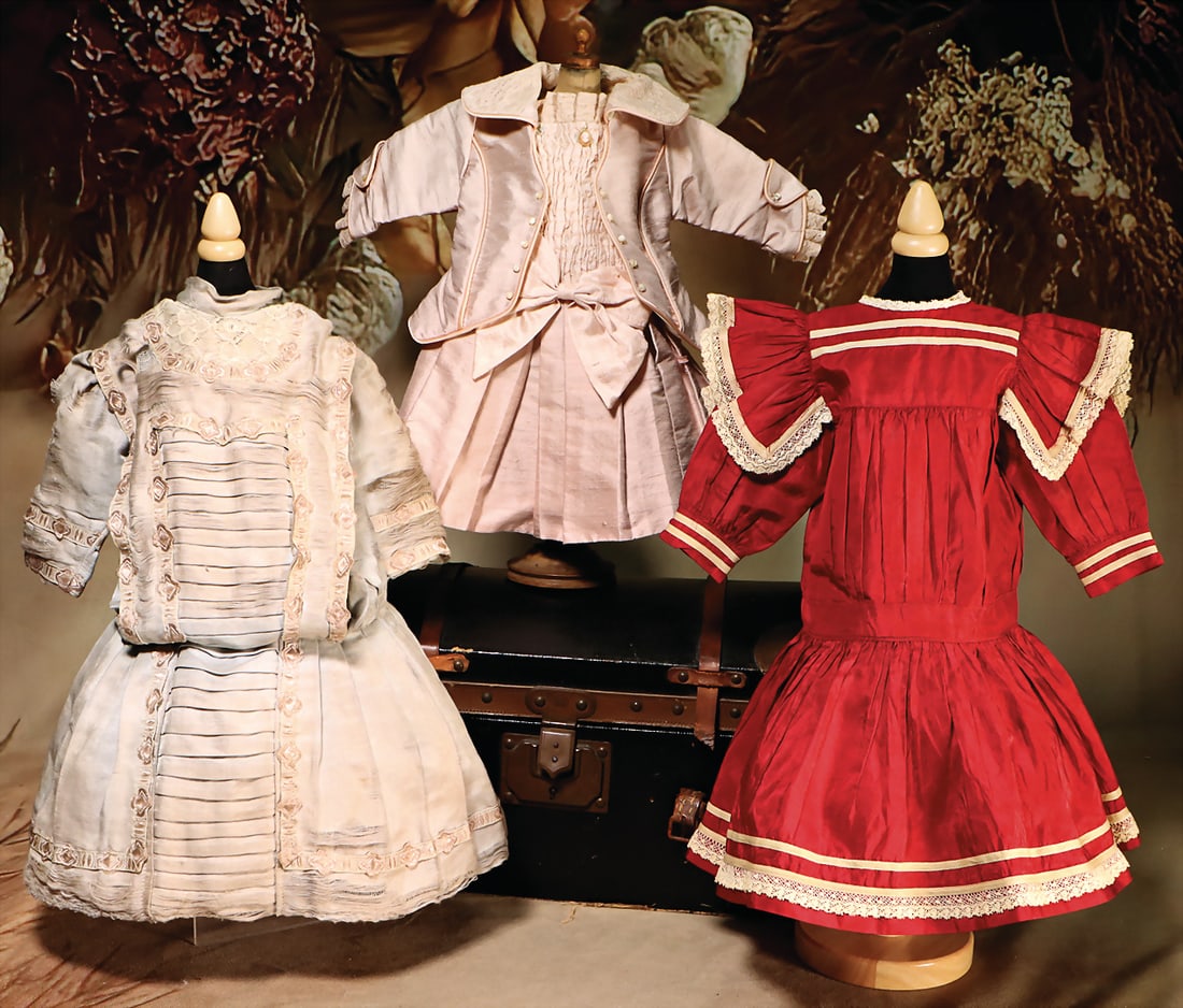 Early franc. Doll's Trousseau trunk, according to LP deposé, brown-black leather, corners and: Early franc. Doll's Trousseau trunk, according to LP deposé, brown-black leather, corners and edges lined with rivets, w: 35 cm, d: 21 cm, h: 18 cm, with French doll's robe, 1 bordeaux-red silk d