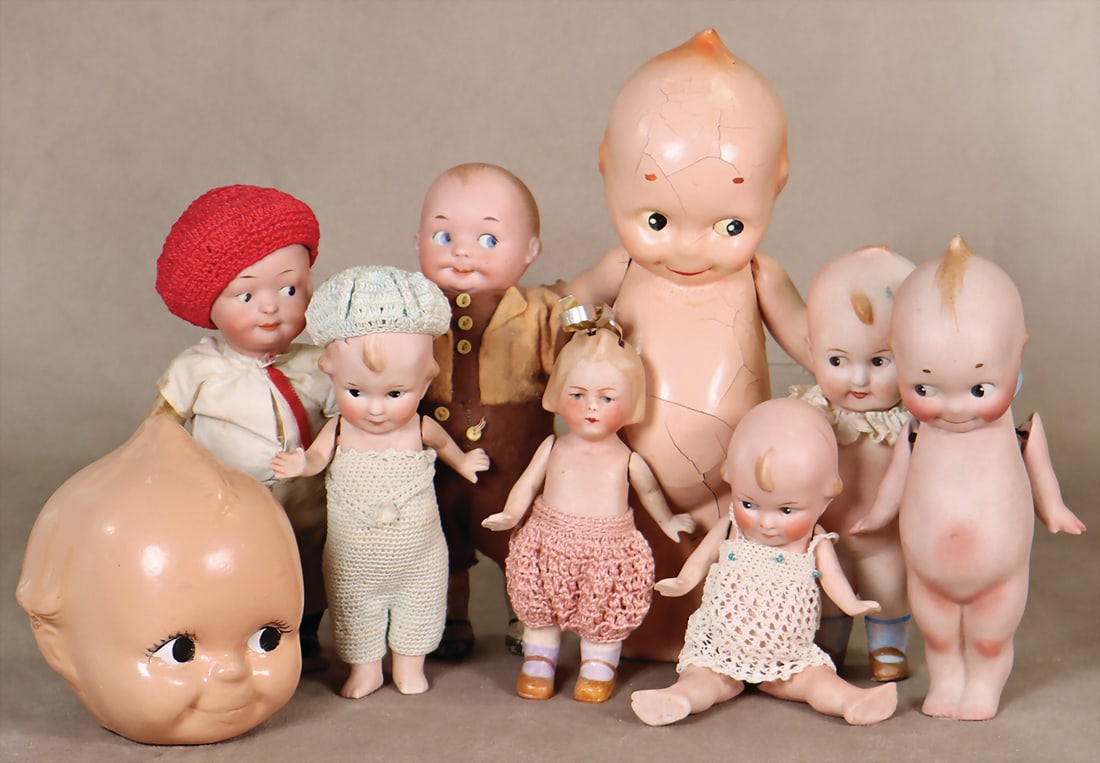 mixed lot of Kewpies, bisque porcelain & celluloid, 1 x marked AM 320, 11, rotating head, painted: mixed lot of Kewpies, bisque porcelain & celluloid, 1 x marked AM 320, 11, rotating head, painted eyes looking sideways, closed, melon mouth, mass body movable, arms & legs, 17 cm, and all bisque Kewp