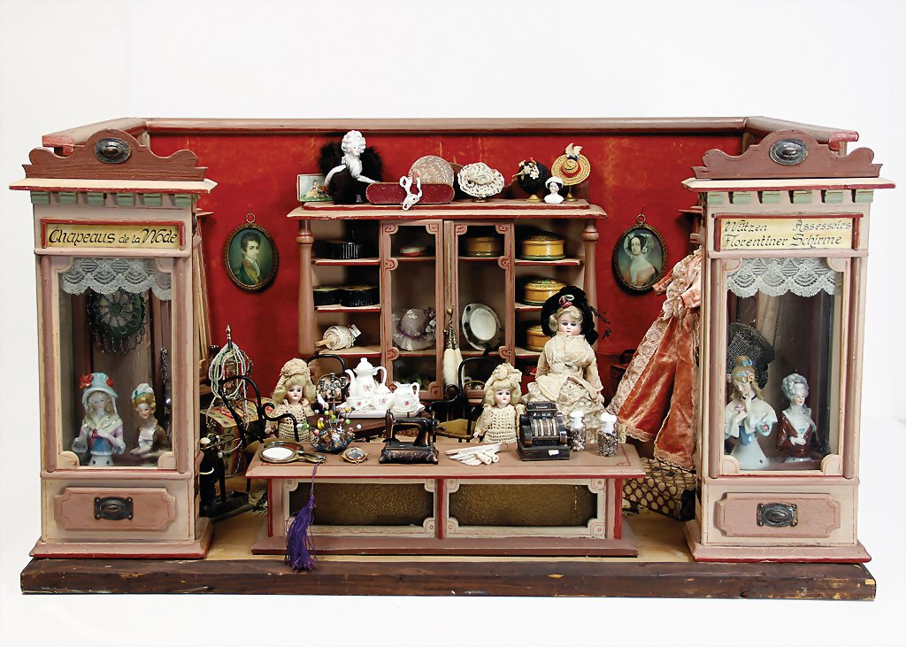 shop, "Chapeaus de la mode", (fashion shop), was: shop, "Chapeaus de la mode", (fashion shop), was aftewards retouched, depth : 56 cm, heigth : 55 cm, width : 87 cm, shopwindow with glass insert, richly accessories, among others porcelain half-dolls,