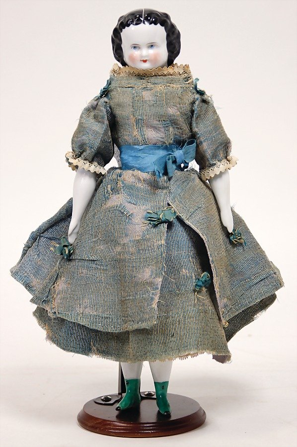 Biedermeier Porzellanbrustblattkopf-Puppe, glasiertes: Biedermeier Porzellanbrustblattkopf-Puppe, glasiertes Porzellan, schwarz modellierte Frisur, auf Stoffkörper, Porzellan-Arme u. Unterschenkel, mit anmodellierten Stiefel u. Strümpfe, 30 cm, 