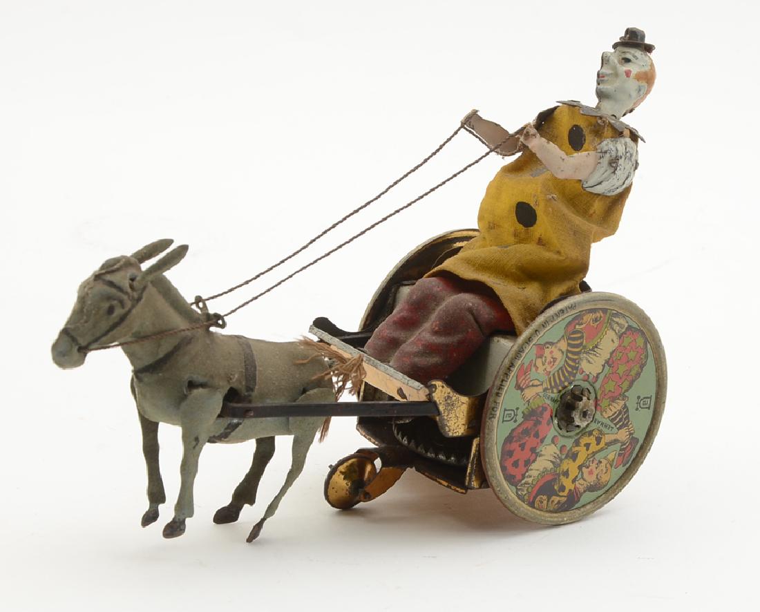 LEHMANN STUBBORN DONKEY TIN LITHO WIND UP TOY: LEHMANN STUBBORN DONKEY TIN LITHO WIND UP TOY: Figure of a clown on a cart with balky felt mule pulling the cart both forward and backward. Key wind movement, measures 5'' h. x 7 1/2'' x 2 3/4''.