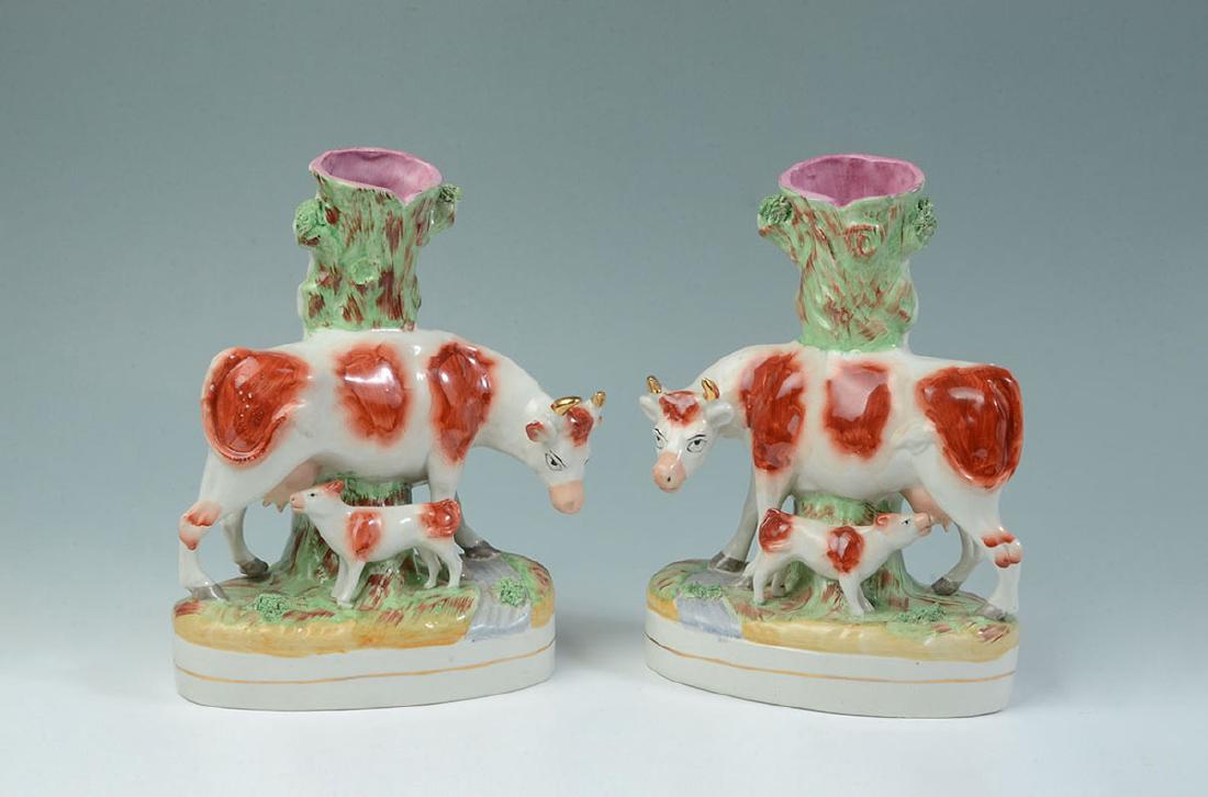 PAIR STAFFORDSHIRE FIGURAL COW SPILL VASES: PAIR STAFFORDSHIRE FIGURAL COW SPILL VASES: Mirror image pair of cow and calf, applied foliage, red Staffordshire Ware England knot mark on bases. Overall 11'' h. x 8 1/2'' x 4''.