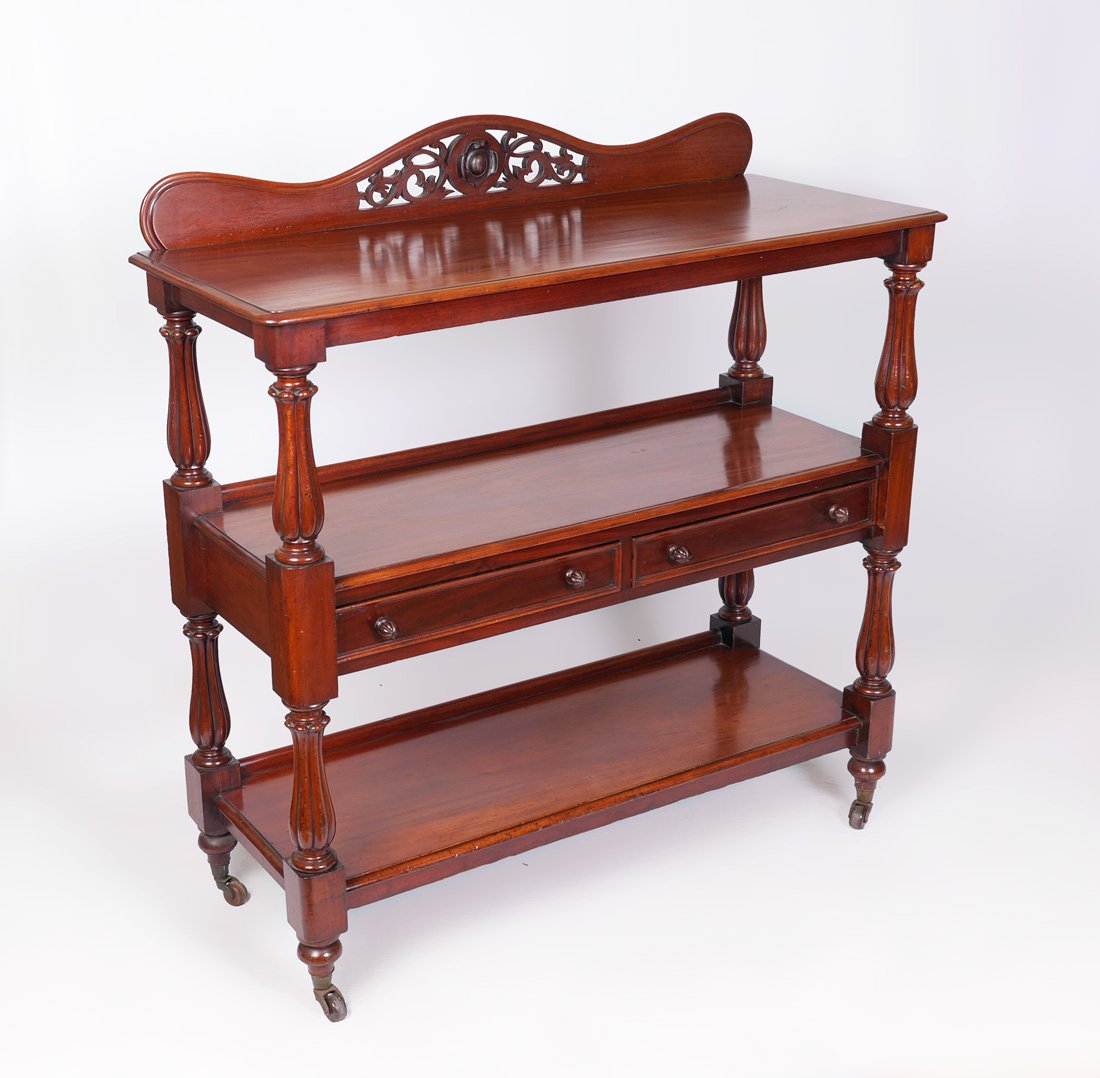 VICTORIAN MAHOGANY 3 TIER SERVER / BUTLERS TROLLY: VICTORIAN MAHOGANY 3 TIER SERVER OR BUTLERS TROLLY: Shaped crest with reticulated foliate design in center, middle shelf with 2 drawers, carved and fluted supports, all on castors. Overall measures 50