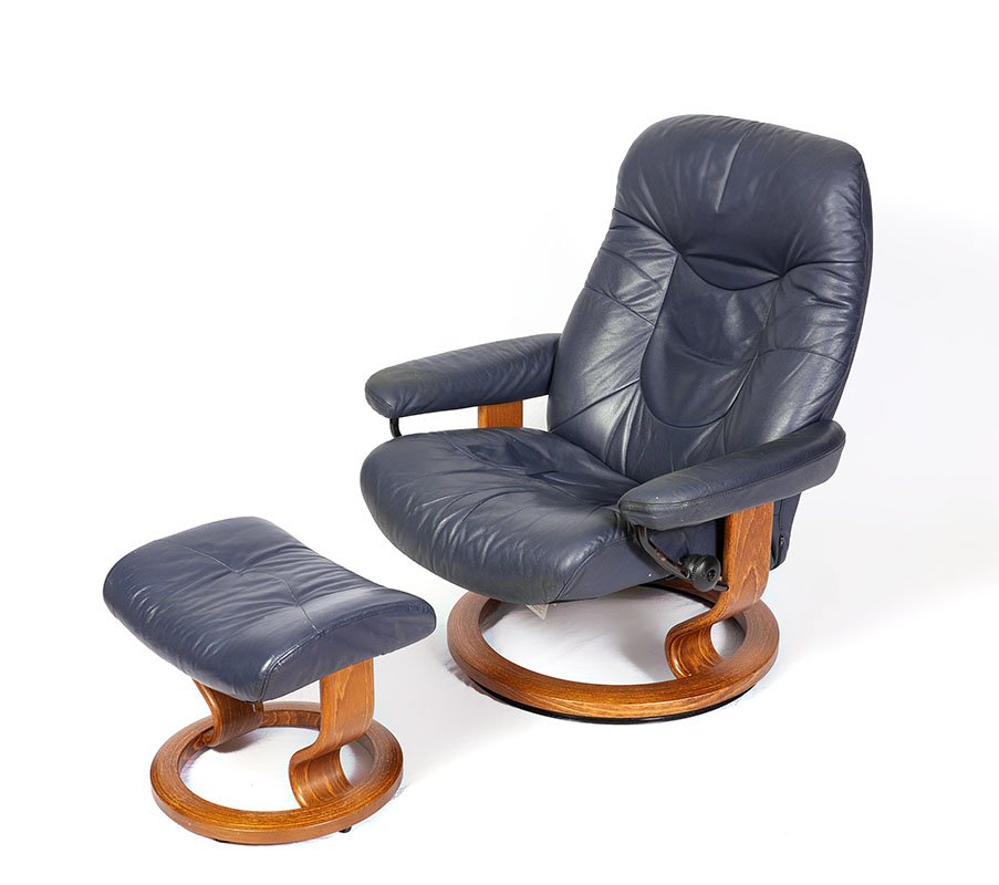 LEATHER EKORNES STRESSLESS RECLINER AND OTTOMAN: NAVY BLUE LEATHER EKORNES STRESSLESS RECLINER AND OTTOMAN: Navy blue leather upholstery with bentwood bases, each marked with Ekornes. Recliner measures 38 1/2" h. x 35 1/2" x 33", ottoman 16" h. x 19