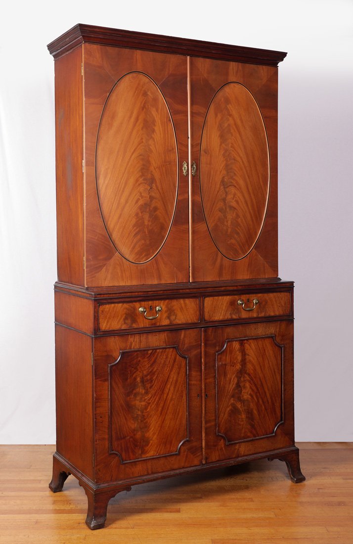 19TH CENTURY ENGLISH MAHOGANY LINEN PRESS: 19TH CENTURY ENGLISH MAHOGANY LINEN PRESS: A marriage of the top and bottom, the 2 blind door top with oval flame mahogany veneer accents. Base with 2 drawers over 2 doors, bracket feet. Overall measu