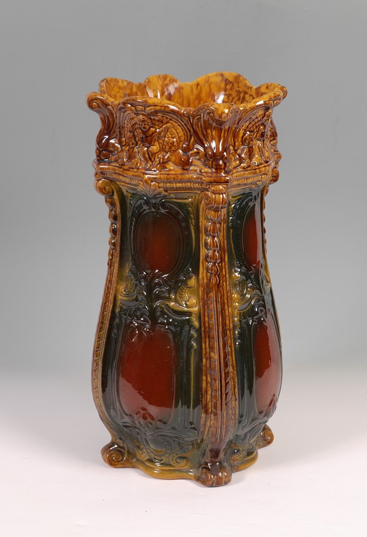 MAJOLICA UMBRELLA STAND: MAJOLICA UMBRELLA STAND: Scalloped rim over figural cherubs, body with slight swell towards base, 24" h. x 12" dia.