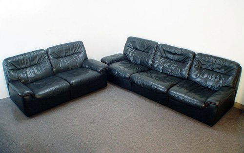 DE SEDE LEATHER SOFA AND LOVESEAT: DE SEDE LEATHER SOFA AND LOVESEAT: Soft Black leather with subtle red piping, the sofa unscrews for shipping, sofa is 29" h. x 8' 8" l. x 33" d., loveseat is 29" h. x 5' 2" l. x 33" d. In used but goo