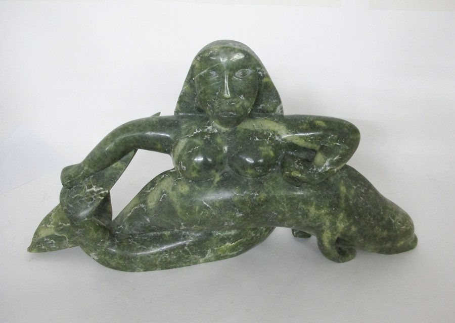 INUIT LARGE CARVED STONE SEDNA & SEAL: INUIT LARGE CARVED STONE SEDNA & SEAL: Large carved stone figure of the Inuit goddess Sedna as a mermaid holding a seal. Overall measures 15 1/2" h. x 29" x 8 3/4".