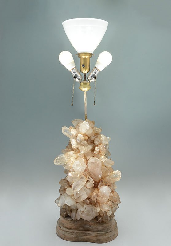 CAROLE STUPELL ROCK CRYSTAL FORMATION LAMP: CAROLE STUPELL ROCK CRYSTAL FORMATION LAMP: Oversize quartz rock crystal formation with plaster backing, on shaped wood base. 3 light fixture with center light having a milk glass shade. Overall measu