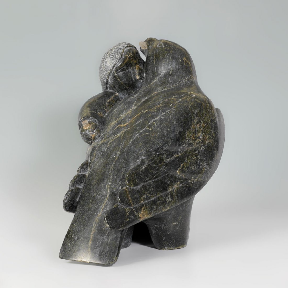 INUIT CARVED STONE FIGURE OF MAN AND EAGLE: INUIT CARVED STONE FIGURE OF MAN AND EAGLE: Large stone carved figural group of a man and eagle that appear to be in battle as the man has a partial crystal in his hand, the other half of crystal is i