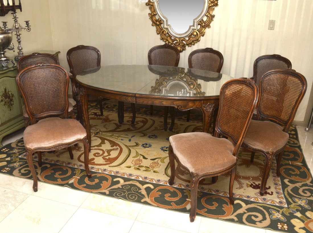 FRENCH STYLE CARVED BAKER DINING TABLE & 8 CHAIRS: FRENCH STYLE CARVED BAKER DINING TABLE & 8 CHAIRS: Baker Furniture tagged dining table with banded walnut veneer oval top, carved and shaped skirt and legs, floral motif at joints. Overall measures 26